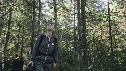 Traveler photographing scenic view in forest. One caucasian woman shooting nice magic look. Girl take photo video on dslr mirrorless camera. Professional photographer travel with backpack. Outdoor.