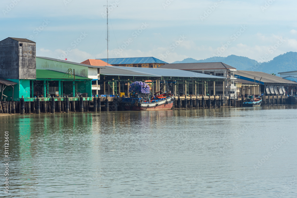 Fishing trawler is moored at the pier in the industrial estate of the Ranong fishing harbor in the south-west of Thailand