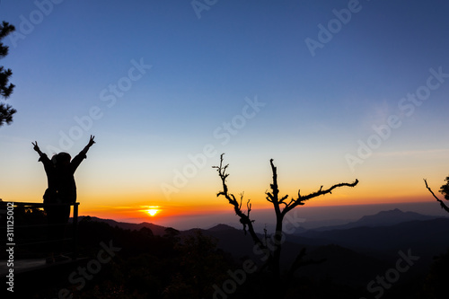 freedom concept, Happy of Woman standing with arms raised up during beautiful sunrise at morning, Enjoy nature At the viewpoint of Chiang Mai, Thailand