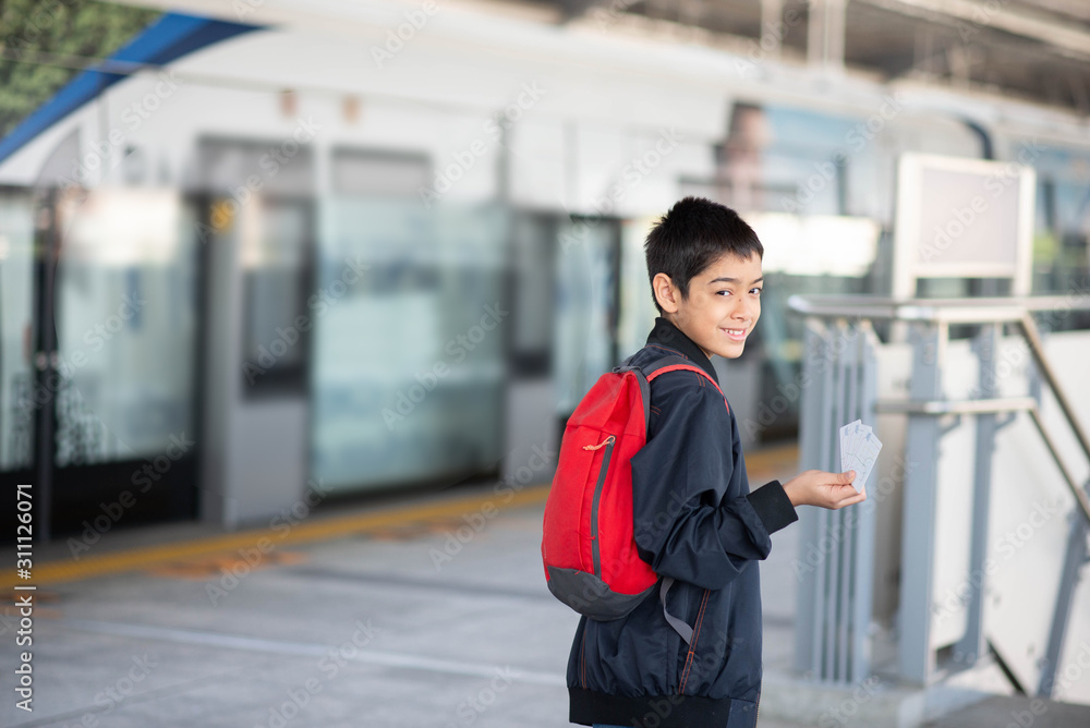 Fototapeta premium Little boy buying electric ticket and walking in the public sky train station with family