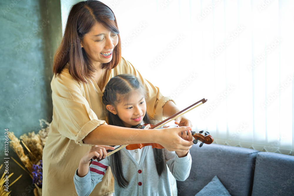 Asian kid learning and practising to play violin at home Asian kid learning and practising to play violin at home