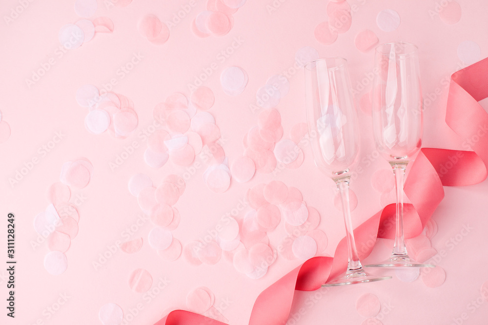 Valentines day greeting card. Empty Wine glasses for wine, confetti and ribbon on soft pink background. copy space, minimal february romance concept, wedding party Valentines day greeting card. Empty Wine glasses for wine, confetti and ribbon on soft pink background. copy space, minimal february romance concept, wedding party