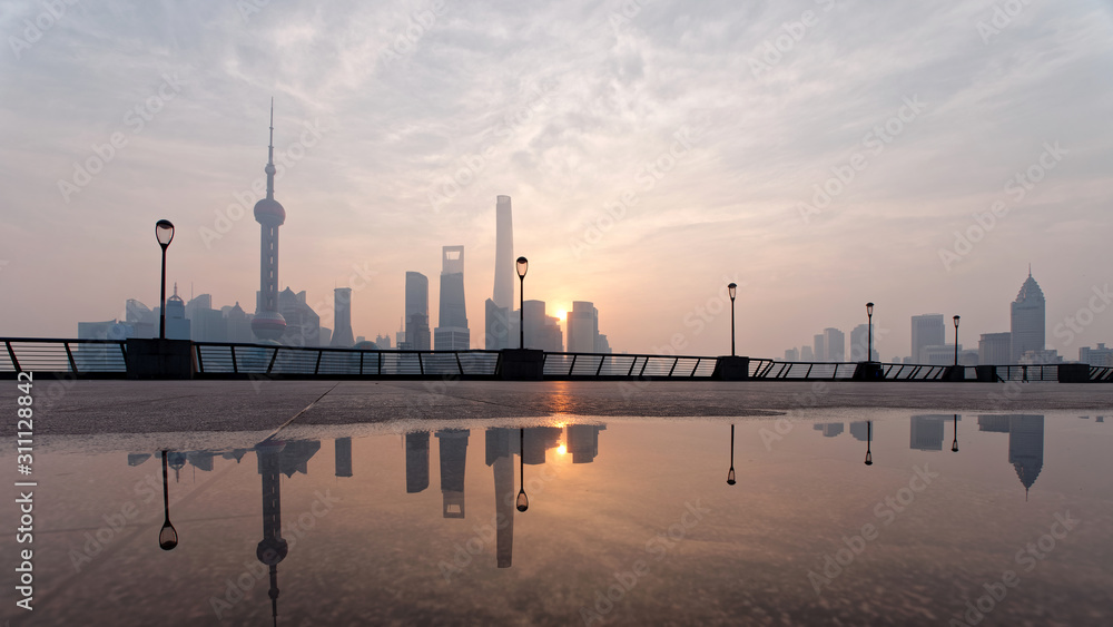 Landscape of Shanghai bund in the morning before sunrise with reflections in water.	