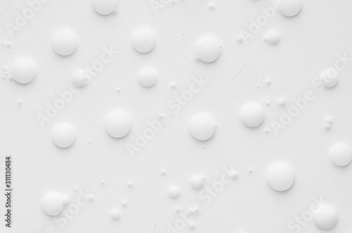 White liquid paint texture with random bubbles and stains as modern abstract background.