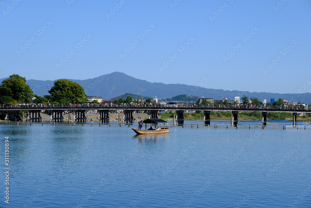 Fototapeta premium 紅葉の時期で賑わう京都嵐山の渡月橋と桂川の風景