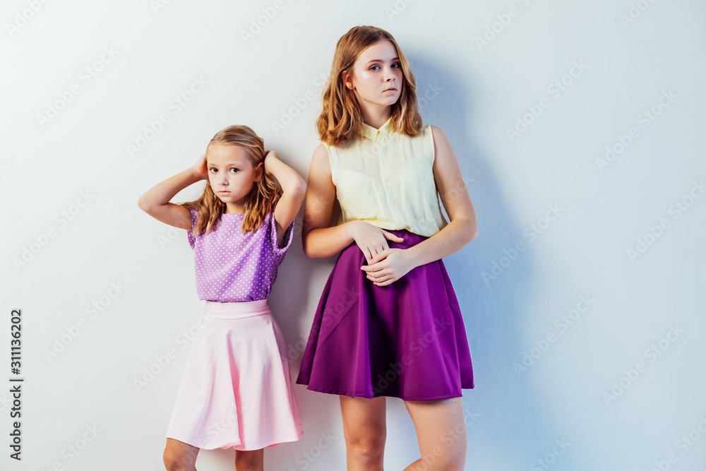 two fashionable girls sisters in beautiful clothes portrait two fashionable girls sisters in beautiful clothes portrait