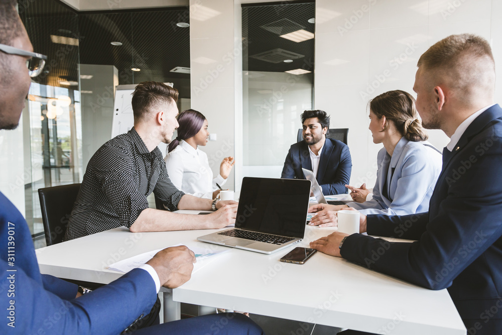 A team of young businessmen working and communicating together in an office. Corporate businessteam and manager in a meeting. A team of young businessmen working and communicating together in an office. Corporate businessteam and manager in a meeting.