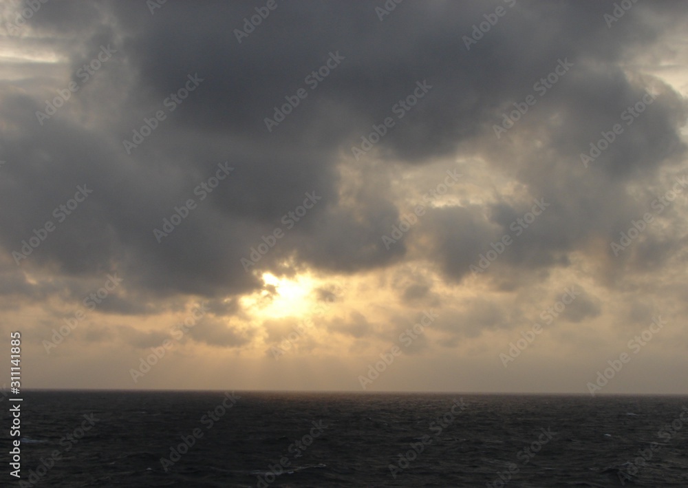  Evening landscape. Sea, sunset through the clouds and cloudy sky in the photo. Sea background.