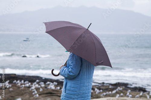 woman off the coast with umbrella