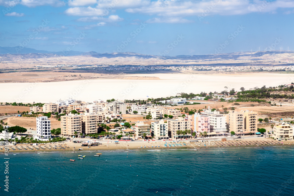 Aerial view at Mackenzie beach with hotel and apartment buildings, sunbeds and umbrellas. It is the beach close to Larnaca International Airport on south of Cyprus island