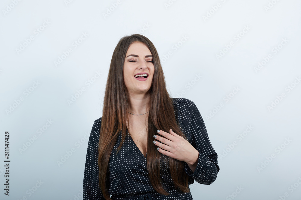 Charming caucasian young woman over isolated gray background wearing casual black dress with white polka dot, keeping eyes closed, relaxing, holding hand on chest. People lifestyle concepte.