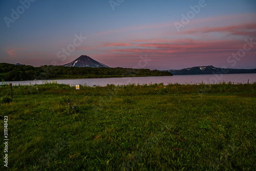 Panoramic view of the city Petropavlovsk-Kamchatsky and volcanoes: Koryaksky Volcano, Avacha Volcano, Kozelsky Volcano. Russian Far East, Kamchatka Peninsula.