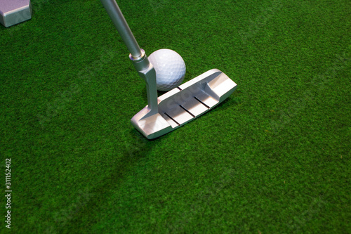 Putter, golf ball and destination for the relaxed office life