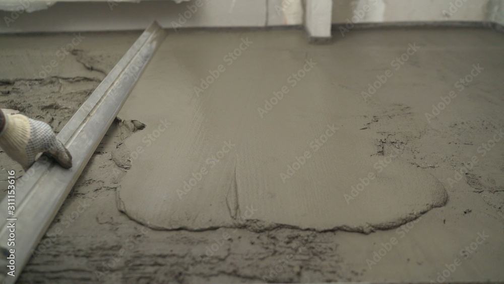 Laying selfleveling floor screed and uniformly spreading with a tool. Leveling the uneven floor