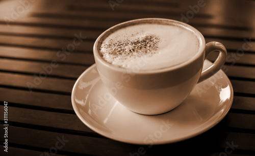 Blurred images of ready-to-drink cappuccino cups placed on a wooden table in the morning as background images and beautiful illustrations