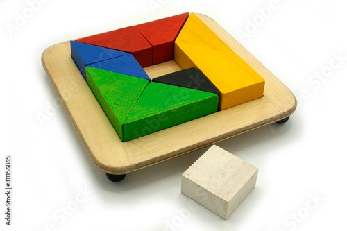 Tangram, Chinese traditional puzzle game made of different colorful wooden pieces that come together in a distinct shape, in a wooden box.