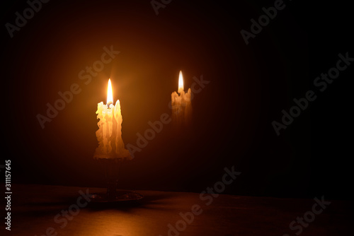 burning candle with reflection in the glass