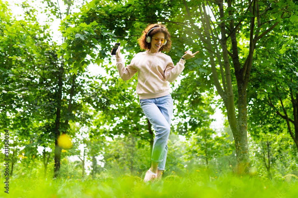 charming girl meditates to music in a summer green park charming girl meditates to music in a summer green park