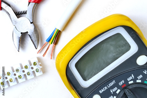 wire cutters, stripped wire, tester and terminal block. on a white background, top view.