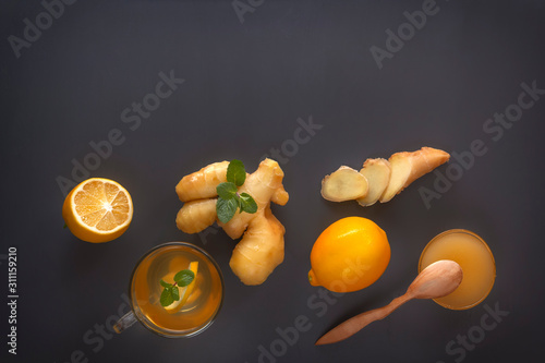 Ginger tea with lemon, honey and mint on a gray wooden table. Copy space. Top view