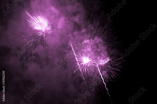 Luxury fireworks event sky show with pink big bang stars. Premium entertainment magic star firework at e.g. New Years Eve or Independence Day party celebration. Black dark night background