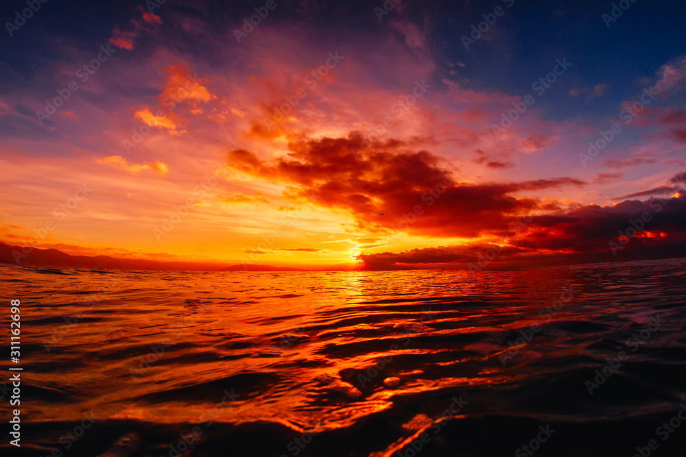 Quiet sea with warm sunset or sunrise colors. Bright sky and ocean