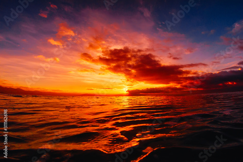 Quiet sea with warm sunset or sunrise colors. Bright sky and ocean