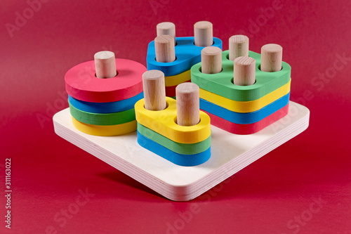 Obraz na plátně children's sorter with geometric shapes on a red background selective focus