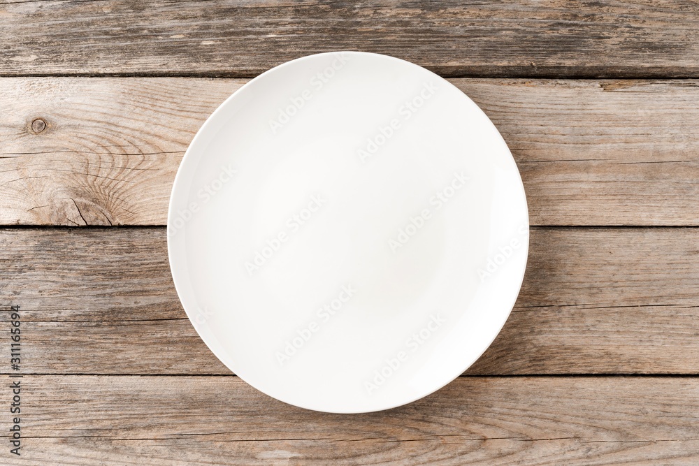 Empty white dish on rustic wooden table. Top view Empty white dish on rustic wooden table. Top view
