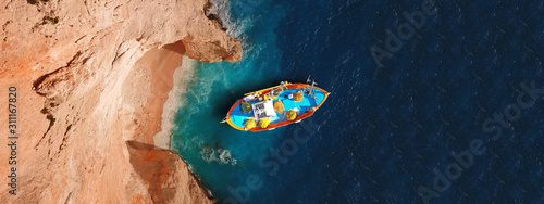 Aerial drone top down photo of traditional wooden fishing boat docked in Zakynthos island, Ionian, Greece © aerial-drone