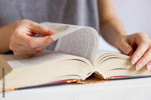 Female hands leafing through pages of books. Closeup open book, reading concept background