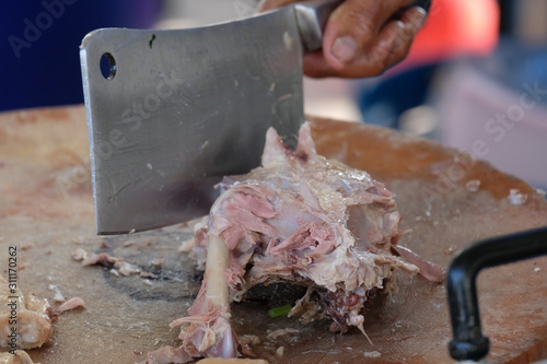 Cutting chicken on butcher wooden.