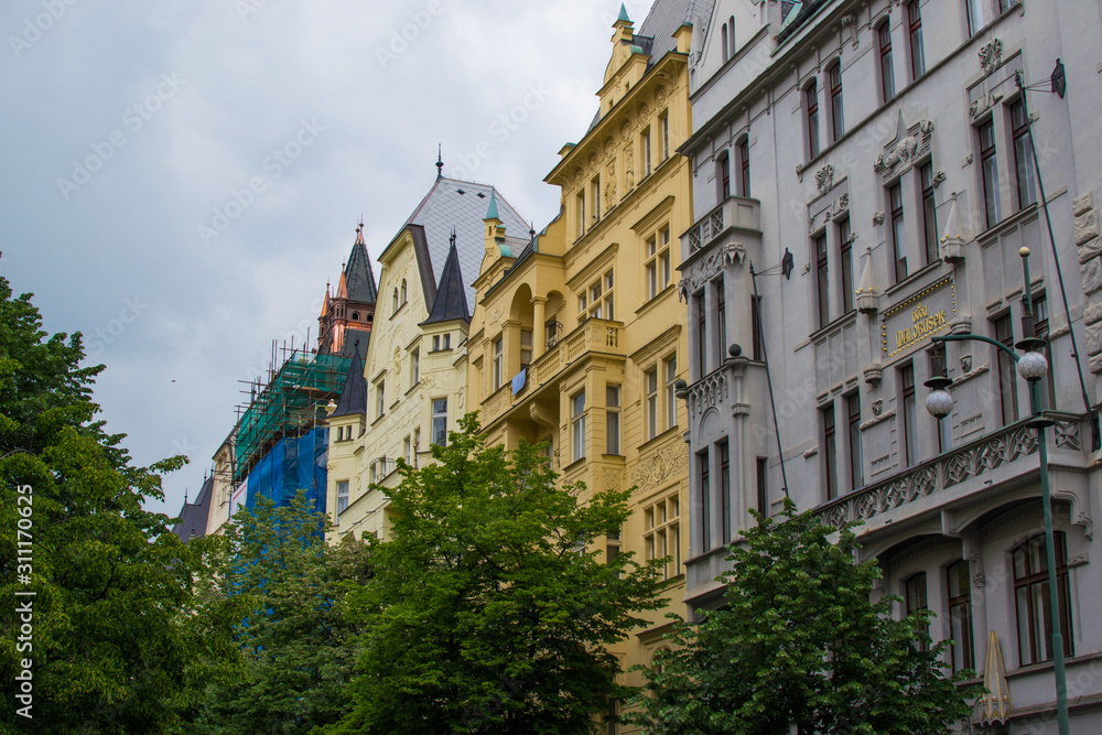 Naklejka premium Facade of typical colorful czech houses with trees at the foreground in Prague, Czech Republic