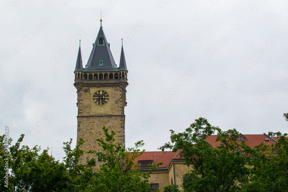 Tower of Old Town Hall (Staroměstská radnice) in the Old Town Square (Staroměstské náměstí) of Prague, Czech Republic, with trees at the foreground