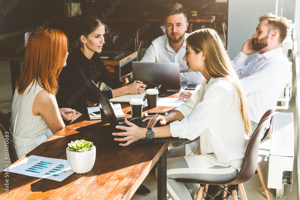 A team of young businessmen working and communicating together in an office. Corporate businessteam and manager in a meeting. A team of young businessmen working and communicating together in an office. Corporate businessteam and manager in a meeting.