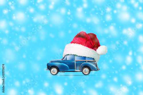 Retro car in Santa's hat on a blue background. Copy Space. Christmas. New year background.