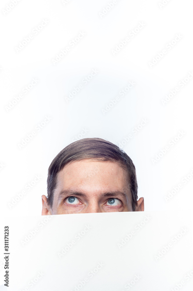 The person's face is covered with a white piece of paper, on an isolated background. The person's face is covered with a white piece of paper, on an isolated background.