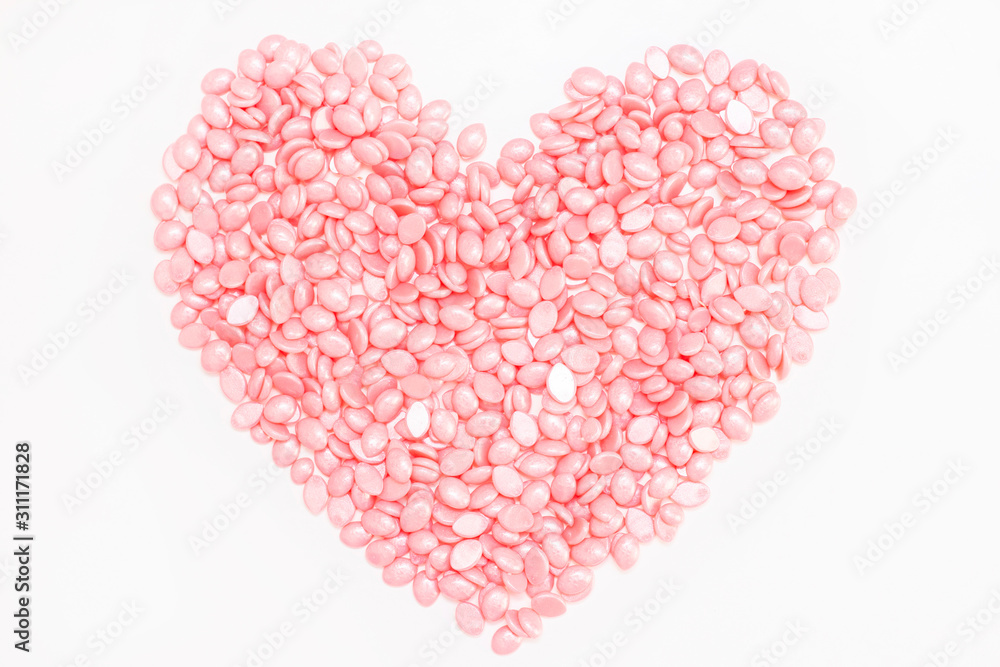 Wax for depilation of pink color. in the form of a heart. On white background. The concept of waxing, smooth skin.