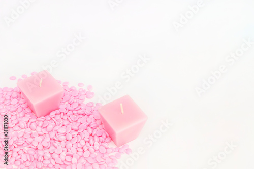 background texture wax for depilation of pink color on a white background with candles. space for your copy space text. The concept of depilation, waxing, smooth skin without hair.