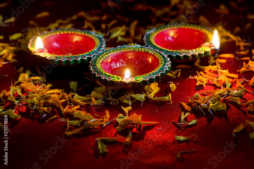 Happy Diwali - Clay Diya lamps lit during Diwali celebration. Greetings Card Design of Indian Hindu Light Festival called Diwali photo