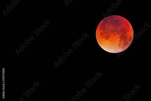 Bloody moon, full moon against black sky background, copy space to the left