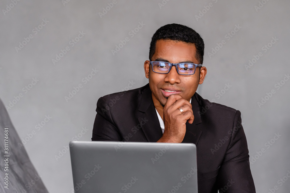 Portrait of a positive and natural african american male businessman in formally attire posing over gray background. Successful business people concept. Advertising space Portrait of a positive and natural african american male businessman in formally attire posing over gray background. Successful business people concept. Advertising space
