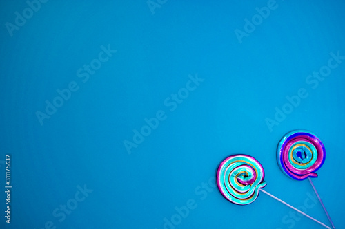 Colorful lollipop swirl on stick. Striped spiral multicolored candy. Copy space. Top view.
