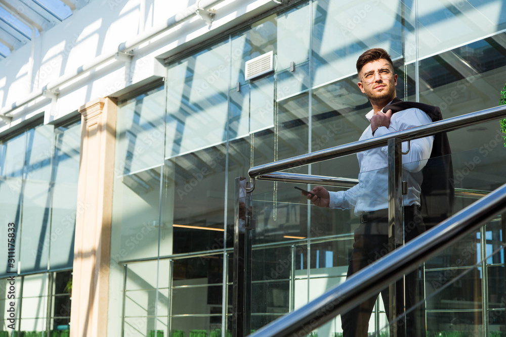 Portrait of a businessman in suit are standing on the background of glass offices. Portrait of a businessman in suit are standing on the background of glass offices.