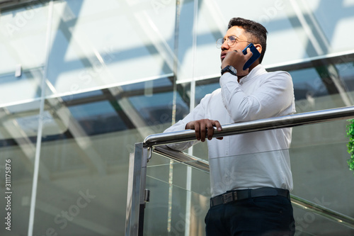 Portrait of a businessman in suit are standing on the background of glass offices.