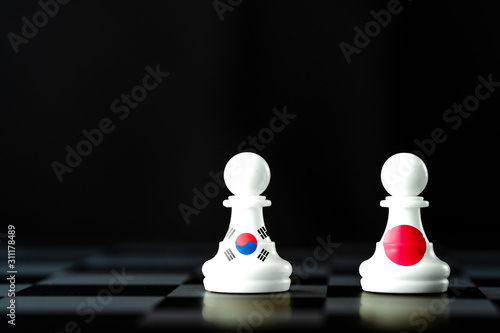 Japan and South Korea flag print screen on Chess on black background. Now both countries have economic and patriotic conflict.