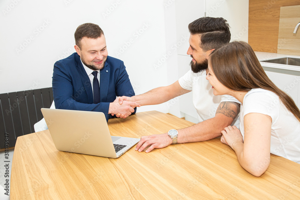 real estate agent shows a young couple a new home. family buys housing real estate agent shows a young couple a new home. family buys housing