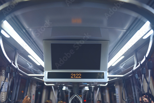 Indoor advertising in public transport. Bus cabin with lcd monitor on ceiling.