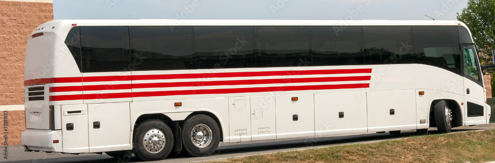 Parked white tour bus with red stripes.