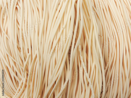Top view of raw thin noodles full of frame. Could be background. Food concept. Asian, Taiwanese cuisine ingredients. Vertical lines. With copy space.